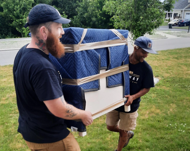 workers picking up a big box with a blue fabric